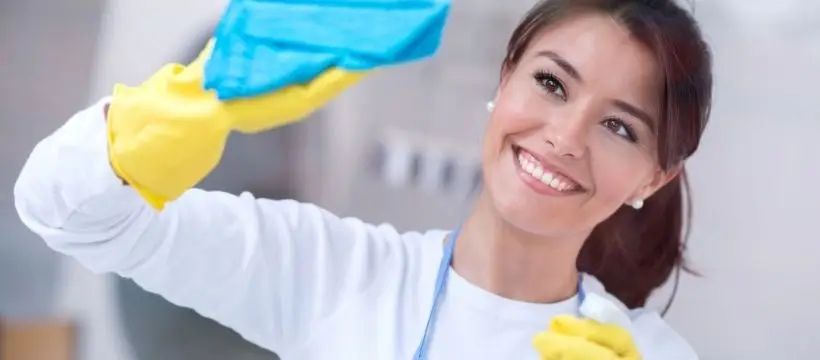 A cheerful housekeeper tidying up.